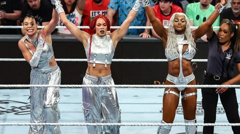 Jade Cargill and a referee hold up the arms of Michin and B-Fab in victory after the team scored a victory on an episode of "WWE SmackDown."