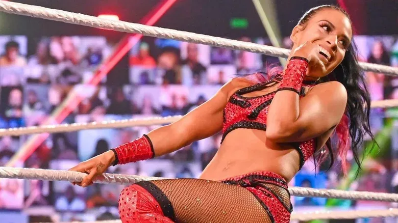 Zelina Vega poses on the ramps and looks toward the hard cam before a match during the "Thunderdome Era" of WWE.