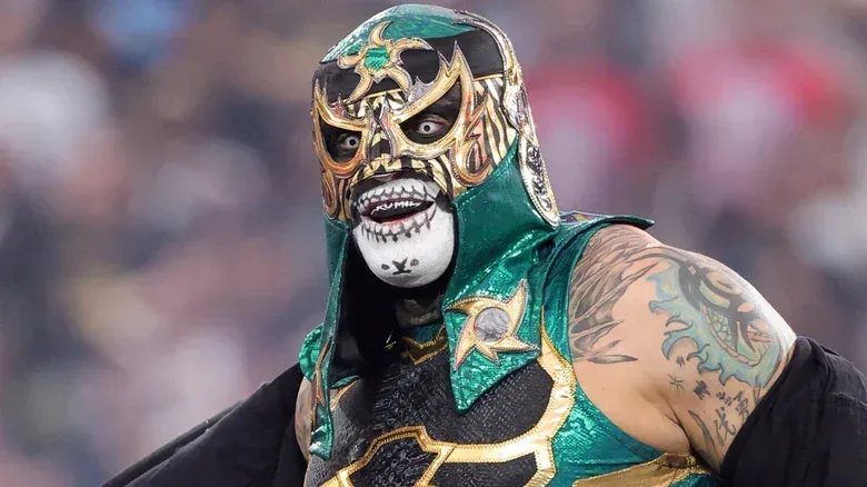 Penta wearing a green and black mask