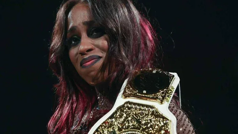 An emotional Naomi smiles toward the crowd ahead of her pregnancy announcement on an August 2025 edition of "WWE Raw."