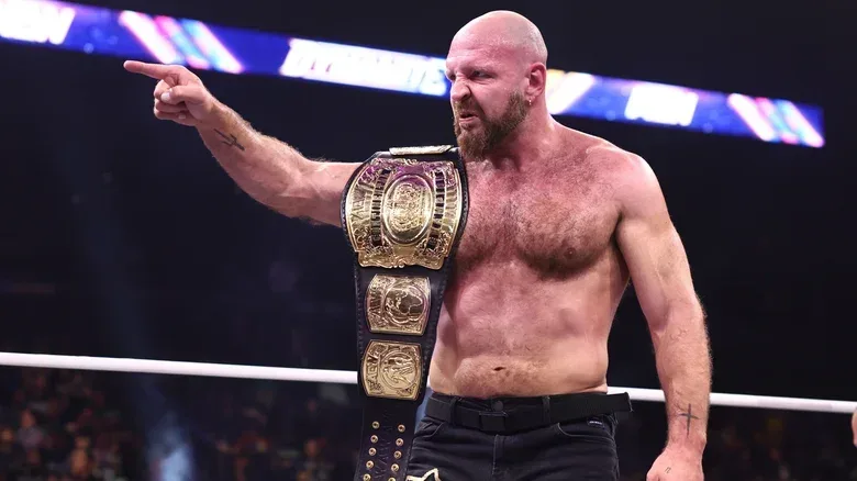AEW Continental Champion Jon Moxley points toward an opponent in the ring, the title belt on his shoulder, during an episode of "AEW Dynamite."