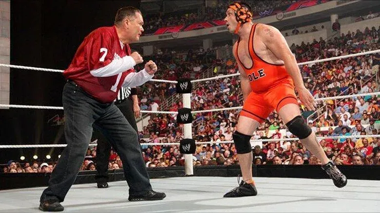 Jim Ross standing off against Michael Cole during an episode of "RAW."