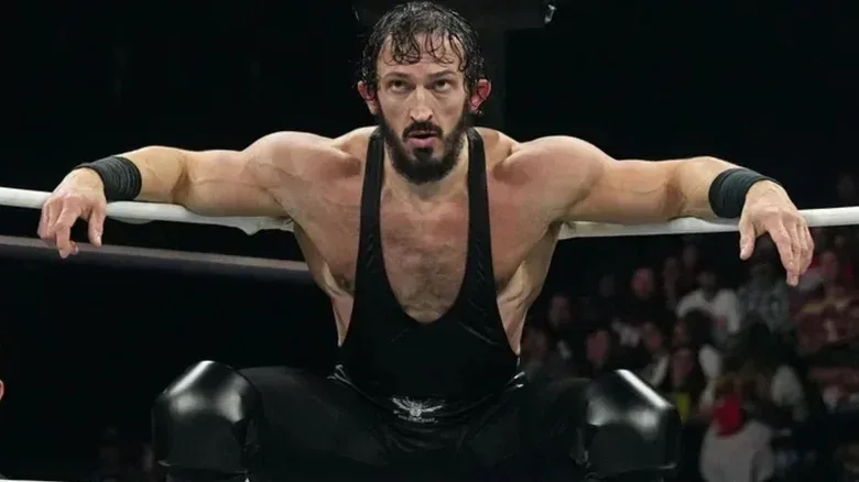 Pac leaning against the ring ropes