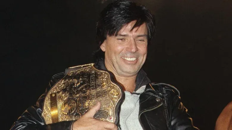 Eric Bischoff with the WCW World Heavyweight Championship across his shoulder during a WCW show.