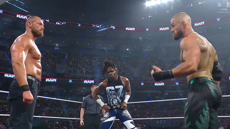 All three men staring down one another in the ring
