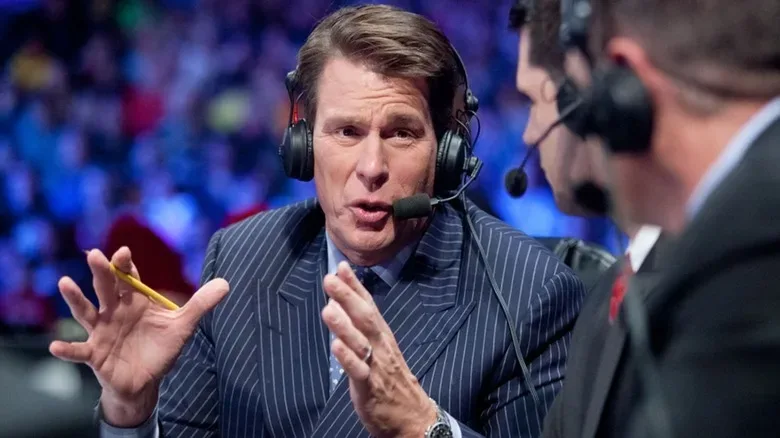 WWE Hall of Famer John Bradshaw Layfield gestures as he speaks on commentary during a WWE match.