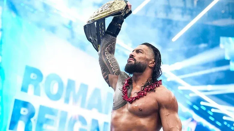 "The OTC" Roman Reigns holds his WWE World Heavyweight Championship high before defending it against Seth Rollins at this year's SummerSlam PLE