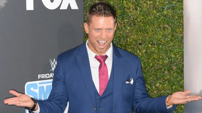 The Miz wearing a blue suit and posing at a promo event